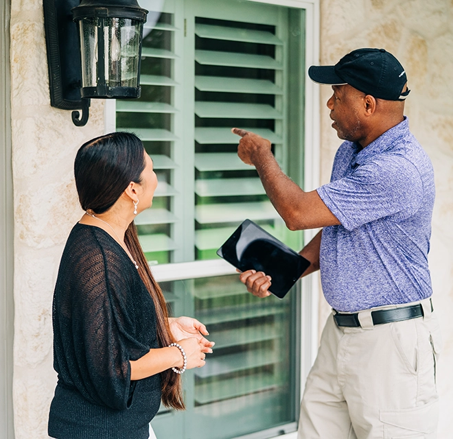 Window Genie professional explaining services to a customer.